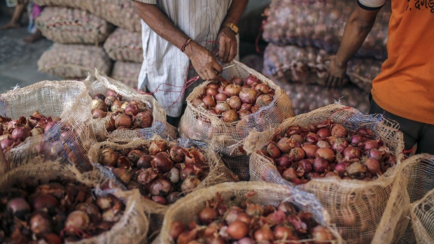 A worker seals a sack of onions at the Vashi Agricultural Produce Market Committee (APMC) wholesale market in Mumbai, India, on Thursday, Oct. 3 2019. Onions in India are once more at the epicenter of a major controversy, pitting government officials who want lower prices against farmers that need extra income.