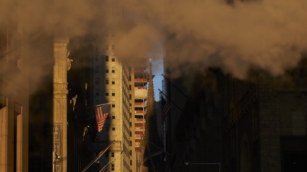 Steam rises above an American flag flying near the New York Stock Exchange (NYSE) in New York, U.S., on Thursday, Dec. 27, 2018. Volatility returned to U.S. markets, with stocks tumbling back toward a bear market after the biggest rally in nearly a decade evaporates. Photographer: John Taggart/Bloomberg