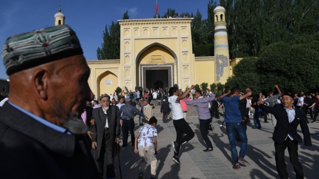This photo taken on June 5, 2019 shows Uighur men dancing after Eid al-Fitr prayers, marking the end of Ramadan, outside the Id Kah mosque in Kashgar, in China's western Xinjiang region.  Photographer: Greg Baker/AFP/Getty Images