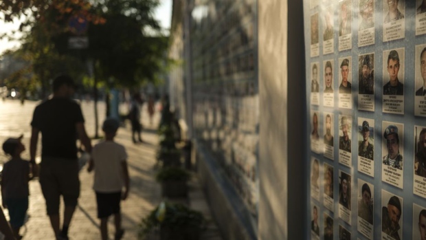 People look over photographs of fallen soldiers in front of the St. Michael's Golden-Domed Monastery as daily life continues amid the Russia-Ukraine war in Kyiv, Ukraine on August 26, 2023. Photographer: Ercin Erturk/Anadolu Agency/Getty Images