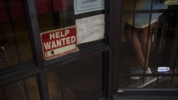A "Help Wanted" sign outside a restaurant in Houston, Texas, U.S., on Friday, April 23, 2021. The U.S. economy is on a multi-speed track as minorities in some cities find themselves left behind by the overall boom in hiring, according to a Bloomberg analysis of about a dozen metro areas.