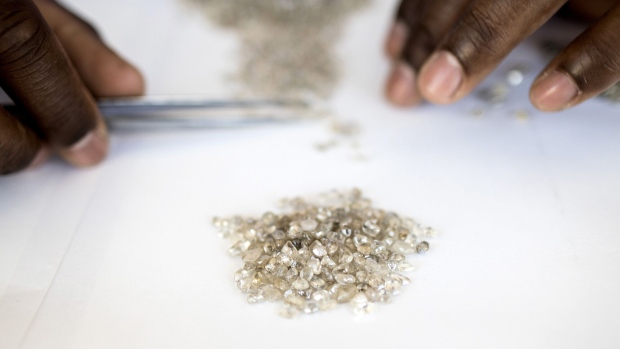 An employee grades a pile of rough diamonds at a processing and valuation center, a joint venture between De Beers Group and Namdeb Diamond Corp. Photographer: Simon Dawson/Bloomberg