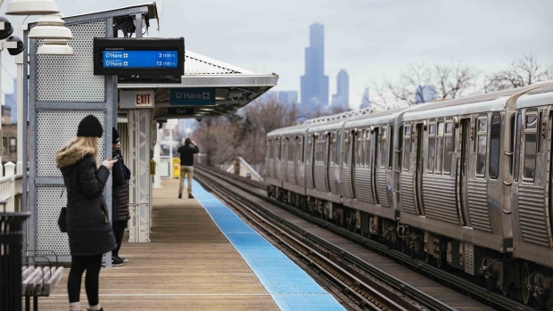 Commuters at the California Blue Line stop in the Logan Square neighborhood of Chicago on Dec. 11, 2022.