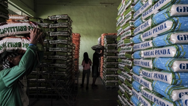 Workers carry high-grade white rice in a warehouse in Bocaue town, Bulacan province, the Philippines, on Friday, July 29, 2022. Philippine President Ferdinand Marcos Jr. has asked agriculture officials to review a law that liberalized rice imports, according to a video of parts of an executive meeting posted on state media’s Facebook.