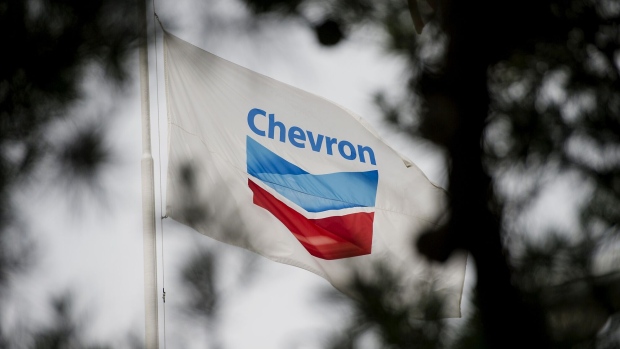 The Chevron Corp. flag flies in front of the company's administrative building inside the Chevron Corp. Richmond Refinery stands in Richmond, California, U.S., on Thursday, April 24, 2014. Chevron Corp. hopes to gain city approval to finish hydrogen plant at the Richmond refinery in June or July.