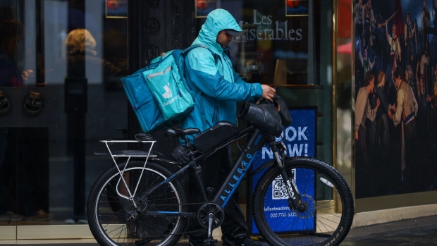 A food delivery courier, working for Deliveroo Plc, uses their phone in Soho, London, UK, on Tuesday, Aug. 8, 2023.  Photographer: Hollie Adams/Bloomberg