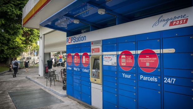 A SingPost POP Station next to a car wash at a Shell PLC service station in Singapore, on Monday, Aug. 22, 2022. As EV sales grow, Shell is reimagining the filling station as a place with coffee, snacks, and space to hang out while recharging the car.