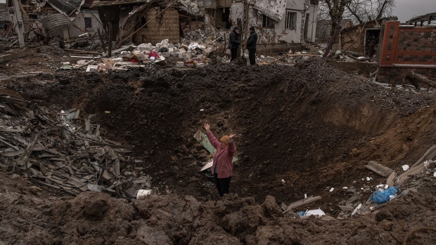 A woman stands in a crater following a Russian missile attack near Kyiv in January.