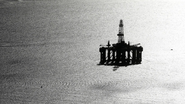 A boat passes a mobile offshore drilling unit in the Port of Cromarty Firth in Cromarty, U.K.