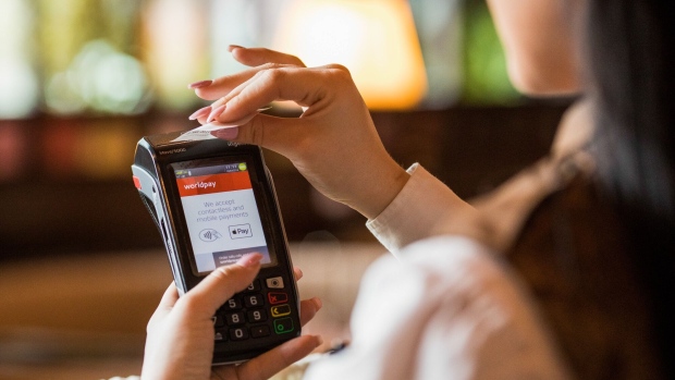 A waitress tears a receipt from a Worldpay Inc. payment terminal at a restaurant in this arranged photograph in London, U.K., on Monday, March 18, 2019. Fidelity National Information Services Inc. agreed to acquire Worldpay Inc. for about $34 billion in cash and stock, the biggest deal ever in the booming international payments sector.