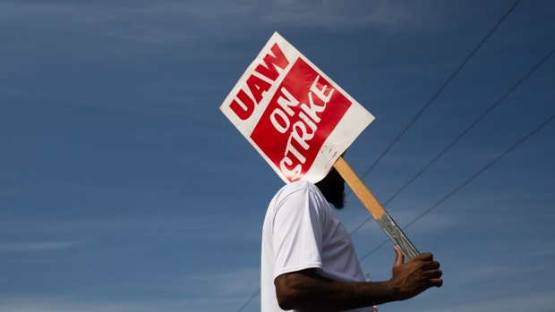 A "UAW On Strike" sign held on a picket line outside the General Motors Co. Ypsilanti Processing Center in Ypsilanti, Michigan, US, on Friday, Sept. 22, 2023. General Motors and Stellantis NV face walkouts at 38 more facilities as talks with their workers' union failed to make headway, even as Ford Motor Co. was spared the escalation after making progress in the negotiations. Photographer: Emily Elconin/Bloomberg