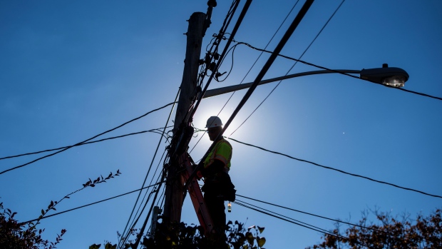The silhouette of a Time Warner Cable Inc. technician is seen performing maintenance on one of the company's network poles in Leonia, New Jersey, U.S., on Friday, Oct. 30, 2015.  Photographer: Ron Antonelli/Bloomberg