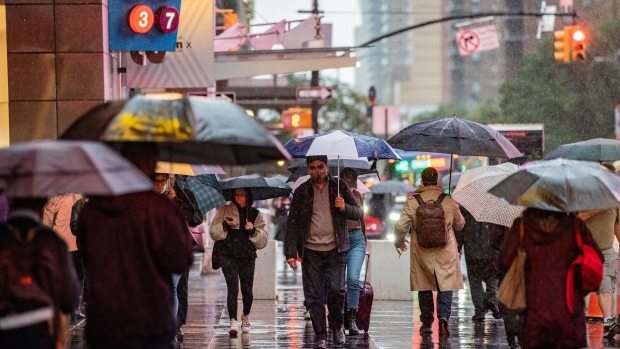 Pedestrians during a rain storm in the Times Square neighborhood of New York, U.S., on Tuesday, Oct. 26, 2021. New York City commuters face a blustery, soaked-to-the-skin trek to work Tuesday as a powerful coastal storm unwinds across the Northeast. Photographer: Jeenah Moon/Bloomberg