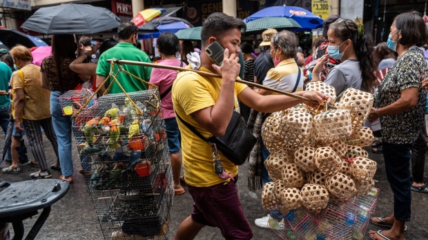 A vendor carries birds and cages through a market in Manila, the Philippines, on Friday, June 2, 2023. Philippine headline inflation could ease early next year below the central bank’s goal of 2% to 4%, Governor Felipe Medalla said, giving monetary authorities leeway on monetary policy. Photographer: Lisa Marie David/Bloomberg