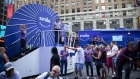 People line up to take photos at a booth displaying SmileDirectClub Inc. signage during the company's initial public offering (IPO) across from the Nasdaq MarketSite in New York, U.S., on Thursday, Sept. 12, 2019. SmileDirectClub Inc. shares declined 12% from their initial public offering price in Thursday's debut.