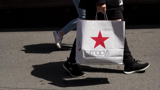 A shopper carries a Macy’s shopping bag in New York City.