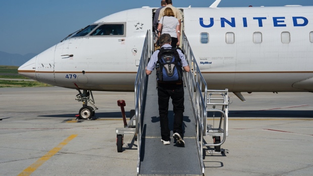 Passengers board a Bombardier CRJ200 jet, operated by United Airlines, at the Sheridan County Airport (SHR) in Sheridan, Wyoming, US, on Saturday, Aug. 19, 2023. Some $5 trillion of capital investment may be needed to deliver on aviation's goal of reaching carbon neutrality by 2050, almost all of it plowed into sustainable fuel production and renewable power generation, according to McKinsey & Co.