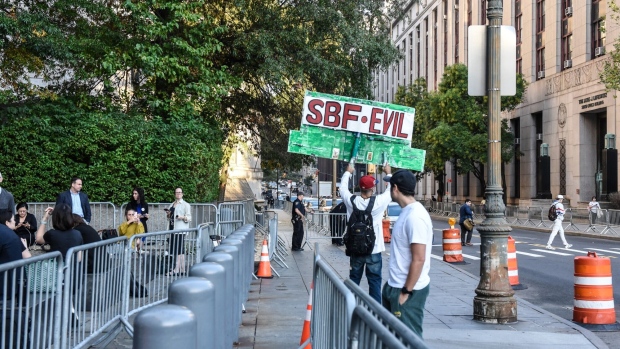 A demonstrator holds a sign reading "SBF Evil" outside court in New York, US, on Wednesday, Oct. 4, 2023. Former FTX Co-Founder Sam Bankman-Fried is charged with seven counts of fraud and money laundering following the collapse of his cryptocurrency empire last year.