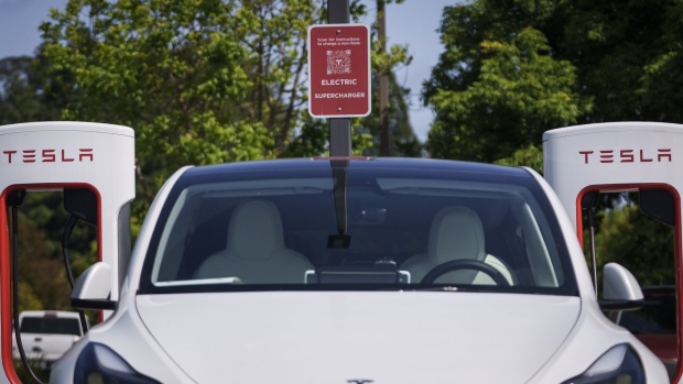 A Tesla Model 3 charges at a Tesla Supercharger location in Scotts Valley, California, US, on Thursday, June 1, 2023. Tesla is making its ubiquitous Superchargers available to other EVs through new corporate partnerships and its Magic Dock. Photographer: Philip Pacheco/Bloomberg