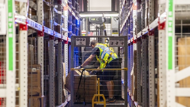 Workers fulfill orders at an Amazon fulfillment center on Prime Day in Melville, New York, US, on Tuesday, July 11, 2023. Amazon.com Inc.’s annual Prime Day shows that e-commerce isn’t the driver it once was for the stock, as investor focus shifts to the company’s faster-growing and profitable cloud-computing unit.