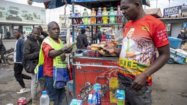 A street vendor exchanges Zimbabwean dollar banknotes with a customer at the bus terminus in the central business district of Harare, Zimbabwe, on Wednesday, July 5, 2023. Consumer prices are climbing at an annual pace of over 100%, sparking jitters in a nation where the scars of hyperinflation run deep.