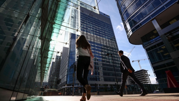 Pedestrians pass 30 Churchill Place, centre, which houses the European Medicines Agency, in the Canary Wharf financial, business and shopping district in London, U.K., on Monday, July 31, 2017. On Tuesday, the European Union is due to announce the cities vying to host the London-based European Medicines Agency and the European Banking Authority after Brexit. Photographer: Chris Ratcliffe/Bloomberg