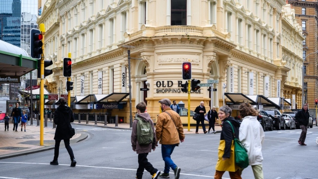 Pedestrians cross a street in a shopping district in Wellington, New Zealand, on Monday, July 10, 2023. New Zealand’s central bank is expected to leave interest rates unchanged this week, ending a streak of 12 consecutive hikes as the economy cools and inflation starts to wane.