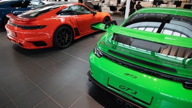 A Porsche 911 turbo, left, and a Porsche GT3 luxury automobile at the Porsche SE showroom in Berlin, Germany, on Tuesday, March 29, 2022. Porsche, which reports reports final year earnings today, delivered 301,915 vehicles to customers in 2021, an 11% jump from 2020 and the first time it has surpassed the 300,000 mark. Photographer: Liesa Johannssen-Koppitz/Bloomberg
