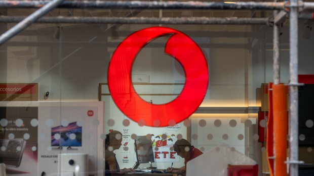 A logo in the window of a Vodafone Group Plc store in Madrid, Spain on Friday Oct. 13, 2023. Spanish investment firm JB Capital is partnering with buy-out fund Apollo for a potential bid for Vodafone’s Spanish unit, newspaper Expansion reports, citing people familiar with the matter.