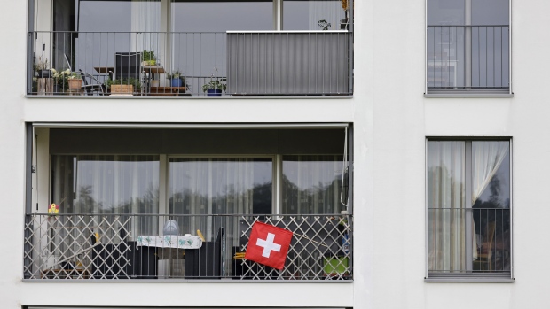 A Swiss national flag on a residential apartment block balcony in Bern, Switzerland, on Tuesday, Aug. 17, 2021. Surging property prices mean Switzerland's residential property market is close to a bubble, according to a UBS Group AG gauge. Photographer: Stefan Wermuth/Bloomberg