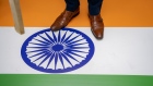 A protester stands on the Indian flag