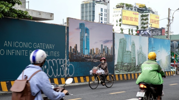 A cyclist rides past an advertisement for housing in District 1 in Ho Chi Minh, Vietnam, on Saturday, Oct. 28, 2023. Ho Chi Minh City’s first-quarter condominium sales fell 23% to a record low due to high interest rates and as funding constraints faced by many developers limited supply. Photographer: Maika Elan/Bloomberg