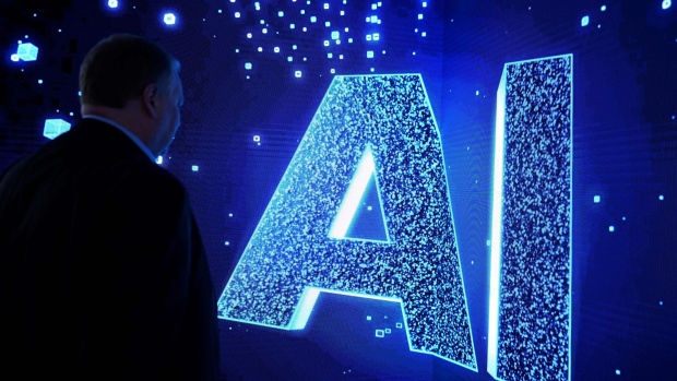 A visitor watches an AI (Artificial Intelligence) sign on an animated screen at the Mobile World Congress (MWC), the telecom industry's biggest annual gathering, in Barcelona. Photographer: JOSEP LAGO/AFP