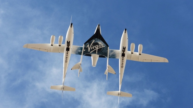 The WhiteKnightTwo mothership, carrying SpaceShipTwo (VSS Enterprise), performs a flyover during an event commemorating the completion of the Virgin Galactic Spaceport America runway in Upham, New Mexico, U.S., on Friday, Oct. 22, 2010.  Photographer: Christ Chavez/Bloomberg
