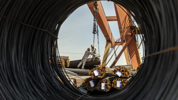 Workers prepare to lift a bundle of steel reinforcing bar with a gantry crane at a metal stock yard in Shanghai, China, on Monday, June 7, 2021.  Photographer: Qilai Shen/Bloomberg