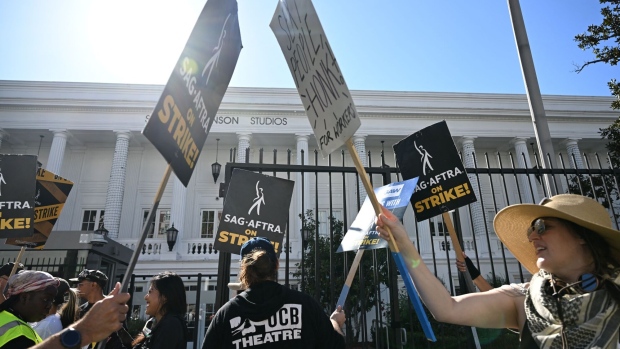 SAG-AFTRA members and their supporters bump signs as they picket outside Netflix during their strike against the Hollywood studios, in Hollywood, California, on November 8, 2023.  Photographer: Robyn Beck/AFP/Getty Images