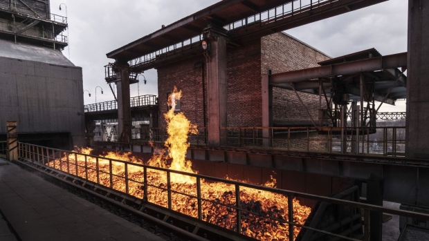 Flames rise from a wagon load of coke following production at the ArcelorMittal steel plant in Kryvyi Rih, Ukraine, on Wednesday, March 6, 2019. ArcelorMittal has made an offer of 48 billion rupees ($672 million) to buy an Essar Power generation plant in India, outbidding the founding Ruia brothers, according to people with knowledge of the matter. Photographer: Vincent Mundy/Bloomberg