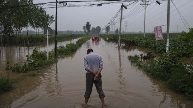 A local resident waits for rescuers at a launch area for boats near Zhuozhou, China on August 3.