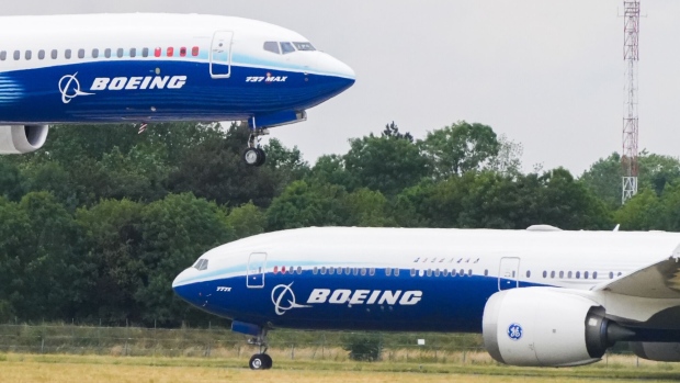 A Boeing 737-10 Max aircraft lands beside a Boeing B777-9 (variant of the B777-X) during a flight demonstration at the Paris Air Show in Le Bourget, Paris, France, on Tuesday, June 20, 2023. At the Paris Air Show, airlines and leasing companies will place orders, manufacturers will show off civil and military aircraft, and executives will tout new technologies like flying taxis and electric propulsion as the industry pushes toward decarbonization. Photographer: Nathan Laine/Bloomberg