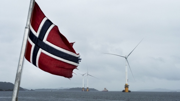 A Norwegian flag flies from a boat near the assembly site of offshore floating wind turbines in the Hywind pilot park, operated by Statoil ASA, in Stord, Norway, on Friday, June 23, 2017. The world's first offshore floating wind farm will be moved to its final destination outside Peterhead, Scotland, later this summer to provide clean energy to 20,000 British households.