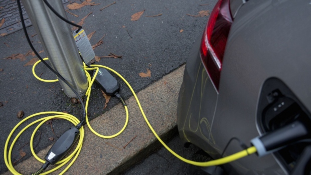An electrical plug connects an electric vehicle (EV) to a charging station at Kongens gate near Akershus festning in Oslo, Norway, on Monday, Nov. 21, 2016. The International Energy Agency forecasts that global gasoline consumption has all but peaked as more efficient cars and the advent of electric vehicles from new players such as Tesla Motors Inc. halt demand growth in the next 25 years.