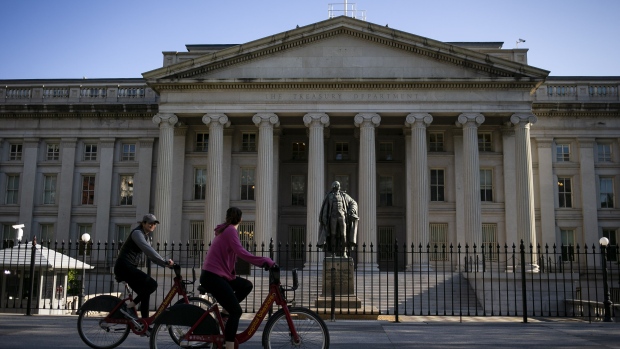 Bicyclists pass the US Treasury in Washington, DC.