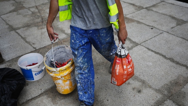 A construction worker carries a bag of plaster on the Unique Tower residential apartment development, owned by Heimstaden Bostad AB, in Warsaw, Poland, on Friday, July 16, 2021. Heimstaden wants to become Poland’s biggest residential property landlord, brushing off concerns that the local housing market may be overheating. Photographer: Piotr Malecki/Bloomberg