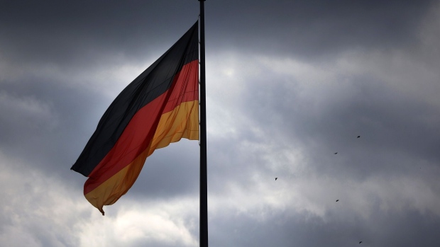 A German national flag outside the Reichstag building in the government district in Berlin, Germany, on Tuesday, Oct. 4, 2022. EU countries are worried that Germany's 200 billion borrowing plan will reopen economic divisions the bloc had managed to bridge during the Covid crisis. Photographer: Krisztian Bocsi/Bloomberg