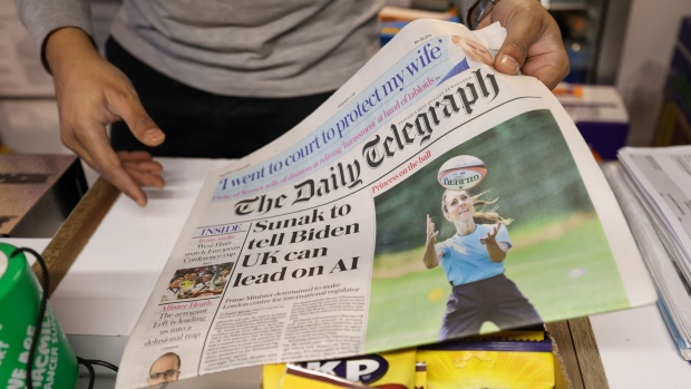 A customer buys a copy of The Daily Telegraph newspaper in London, UK, on Thursday, June 8, 2023. The Telegraph newspapers and Spectator magazine could be sold, after a unit of Lloyds Banking Group Plc appointed receivers to a holding company and removed Barclay family members as directors of the media companies.