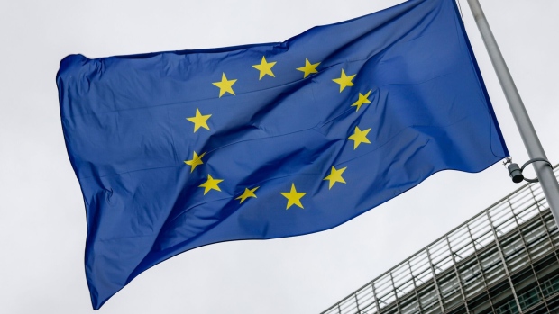 A European Union (EU) flag next to the European Commission building in Brussels, Belgium, on Friday, Nov. 10, 2023. Eurozone countries and the European Central Bank need to coordinate fiscal and monetary policies as they strive to bring inflation down to the ECB’s target of 2%, according to Belgian Finance Minister Vincent Van Peteghem.