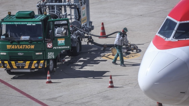 A worker prepares gasoline hoses from a Petroleo Brasileiro SA (PetroBras) truck to refuel a plane at Brasilia-Presidente Juscelino Kubitschek International Airport (BSB) in Brasilia, Brazil, on Wednesday, May 23, 2018. Brazilian politicians, businesses and consumers are feeling the pinch on day three of a nationwide truckers' strike that has prompted fuel shortages and bottlenecks at ports in one of the world's biggest commodity exporters.