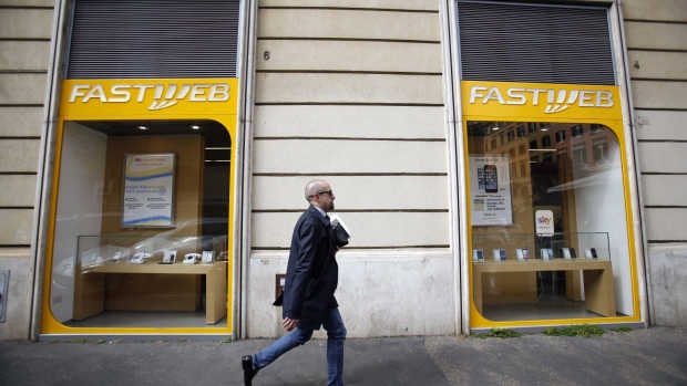 A pedestrian walks past a Fastweb store, operated by Fastweb SpA, in Rome, Italy, on Wednesday, April 2, 2014. Vodafone Group Plc would be helped by adding a fixed-line business to its mobile network in Italy, allowing it to bundle services in a country whose major Internet providers are Telecom Italia SpA, VimpelCom Ltd.'s Wind SpA unit and Swisscom AG's Fastweb unit. Photographer Alessia Pierdomenico/Bloomberg Photographer: Alessia Pierdomenico