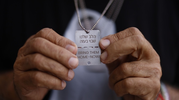 A hostage’s family member displays a style tag that says "Bring Them Home - Now!"  Photographer: Kobi Wolf/Bloomberg