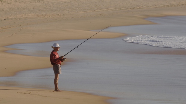 An elderly man fishes from the beach in Sydney. Australia’s do-it-yourself pension plans are unique among developed nations.